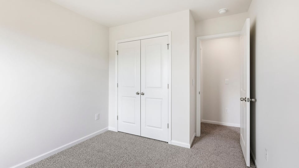 Bedroom with carpet and window.
