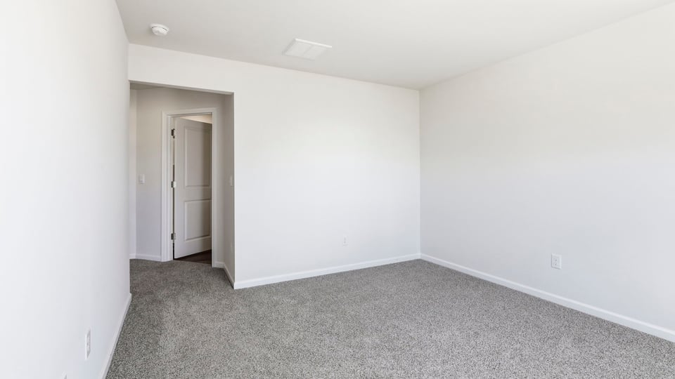 Bedroom with carpet and window.