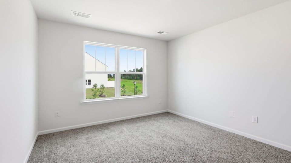 Bedroom with carpet and window.
