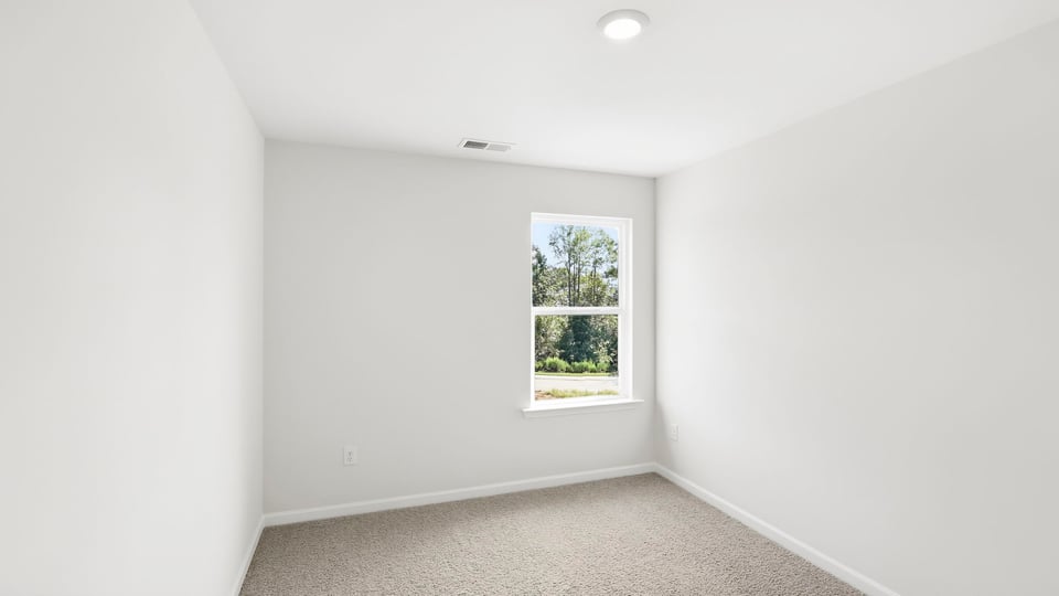 Bedroom with carpet and window.