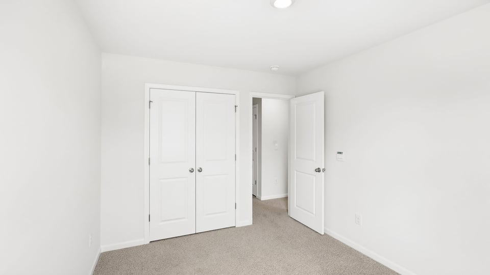 Bedroom with carpet and window.