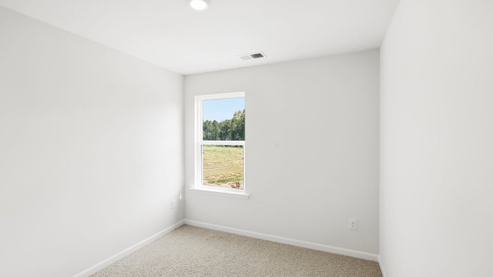 Bedroom with carpet and window.