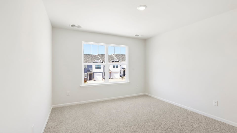 Bedroom with carpet and window.