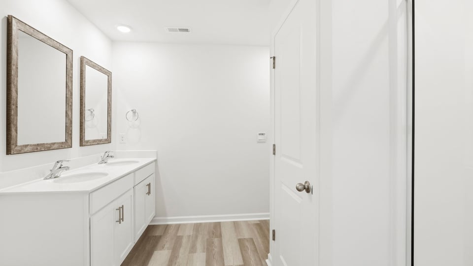 Bathroom with double vanity sink and shower.