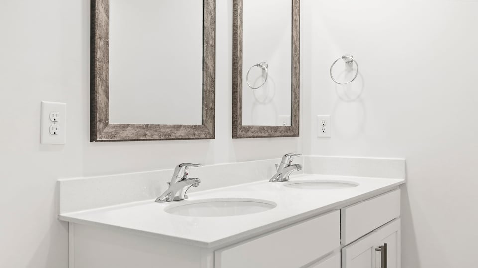 Bathroom with double vanity sink and shower.