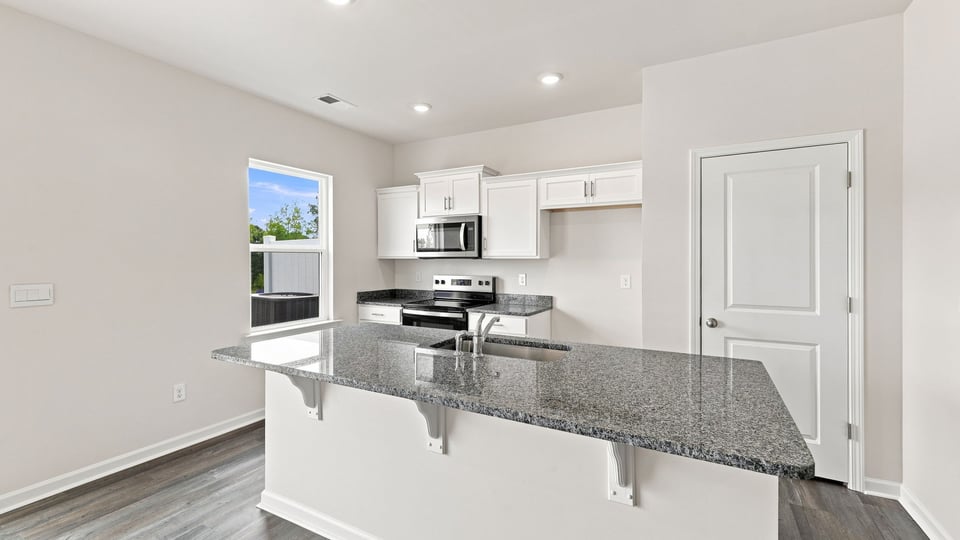 Kitchen and island with stainless steel appliances.