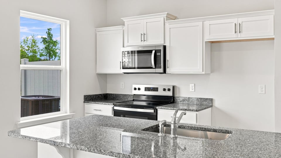 Kitchen and island with stainless steel appliances.