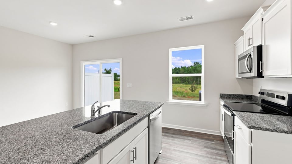 Kitchen and island with stainless steel appliances.