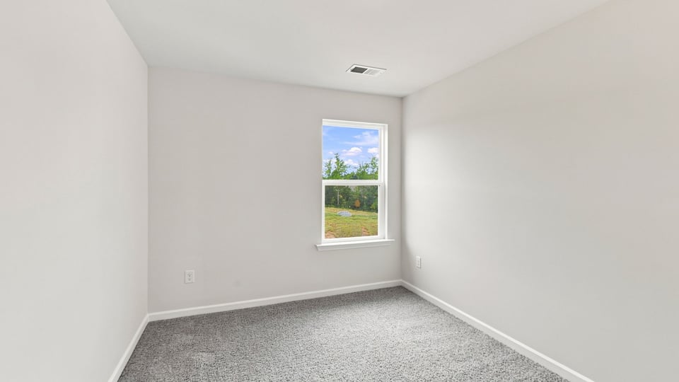 Bedroom with carpet and window.