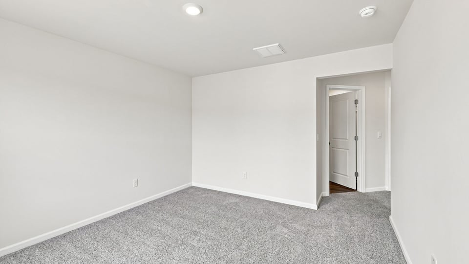 Bedroom with carpet and window.