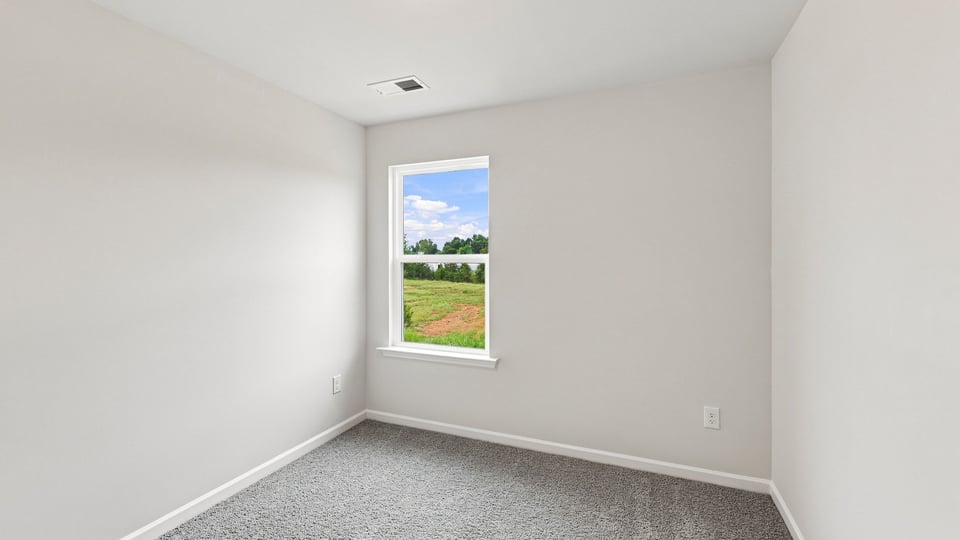 Bedroom with carpet and windows.