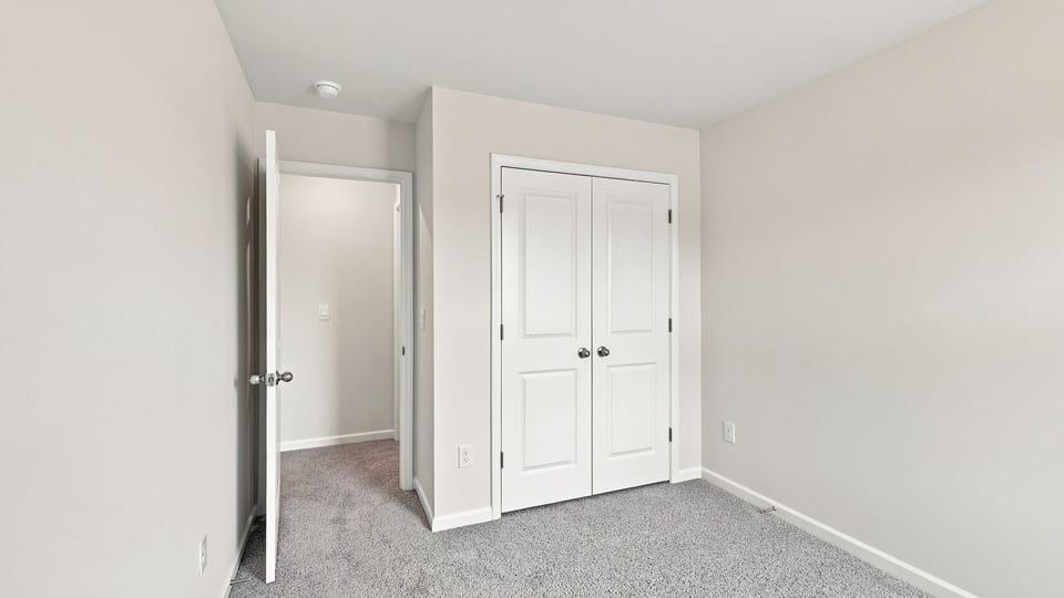 Bedroom with carpet and windows.