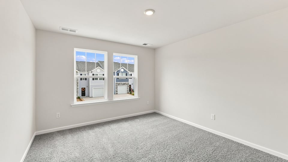 Bedroom with carpet and windows.