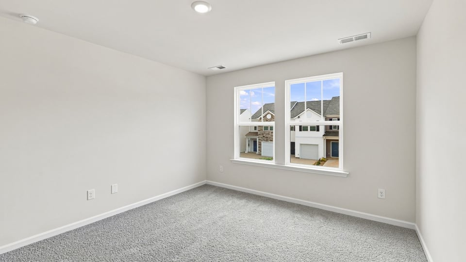 Bedroom with carpet and windows.