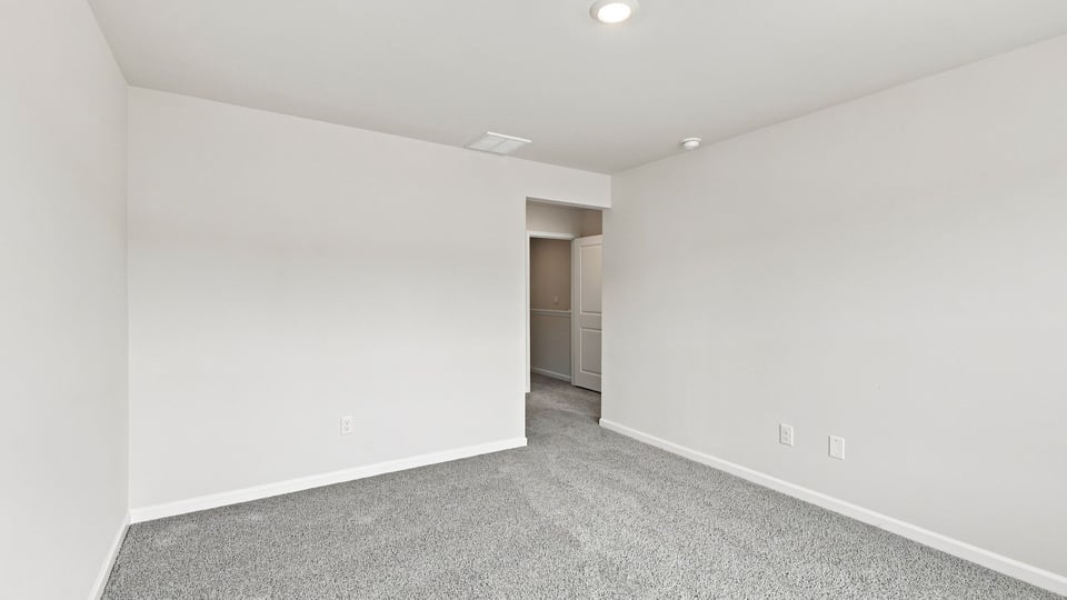 Bedroom with carpet and windows.