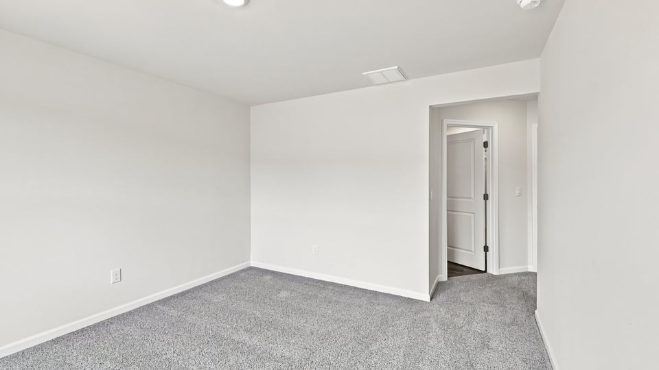 Bedroom with carpet and windows.
