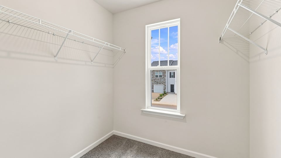 Closet with window and shelf.