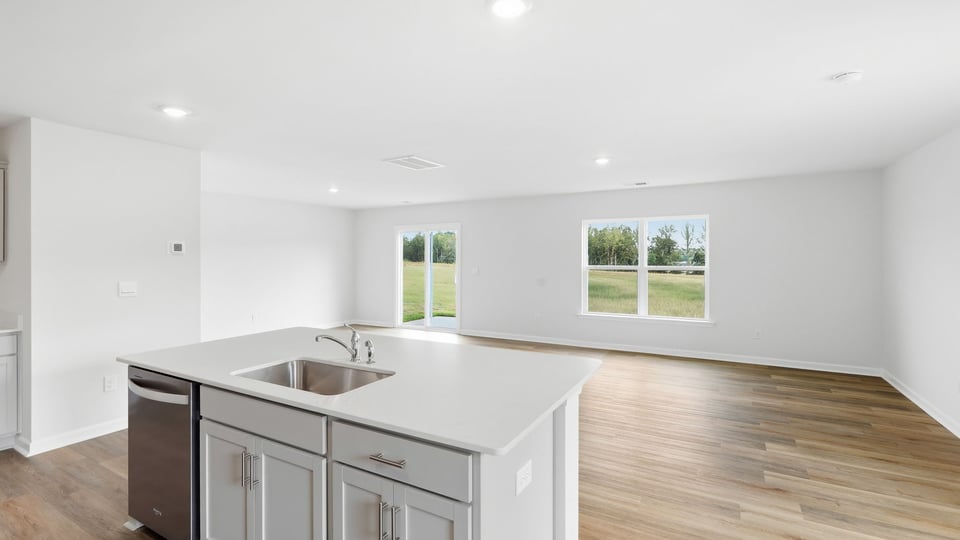 Kitchen and island with quartz countertops and stainless steel appliances.