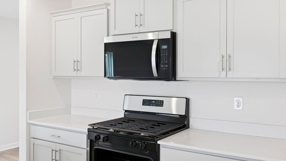 Kitchen and island with quartz countertops and stainless steel appliances.