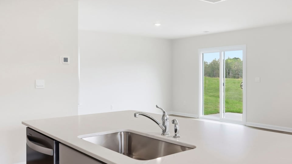 Kitchen and island with quartz countertops and stainless steel appliances.