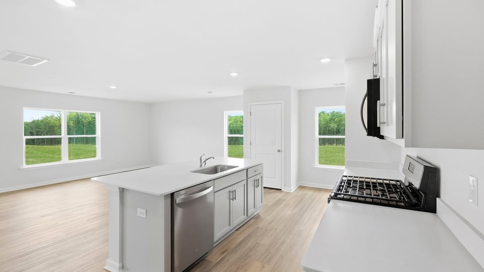 Kitchen and island with quartz countertops and stainless steel appliances.