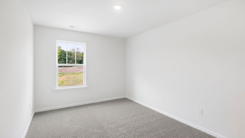 Bedroom with carpet and window.