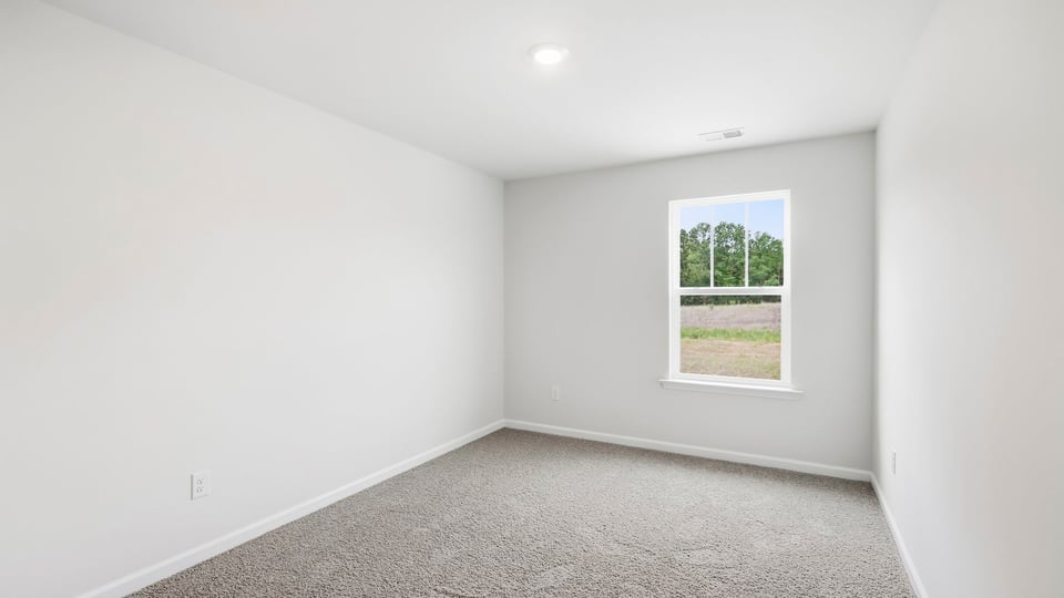 Bedroom with carpet and window.
