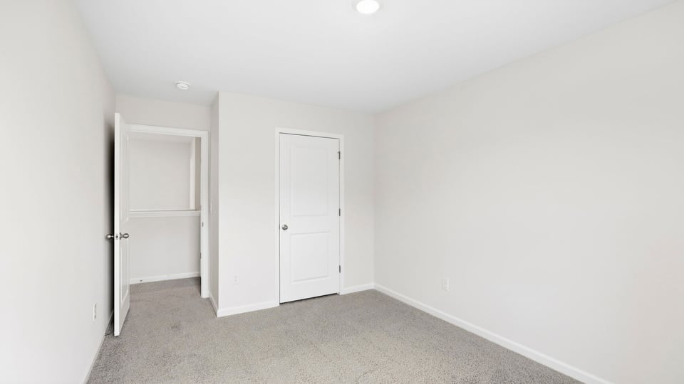 Bedroom with carpet and window.