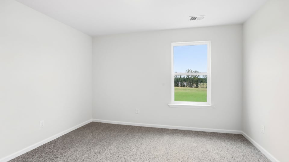 Bedroom with carpet and window.