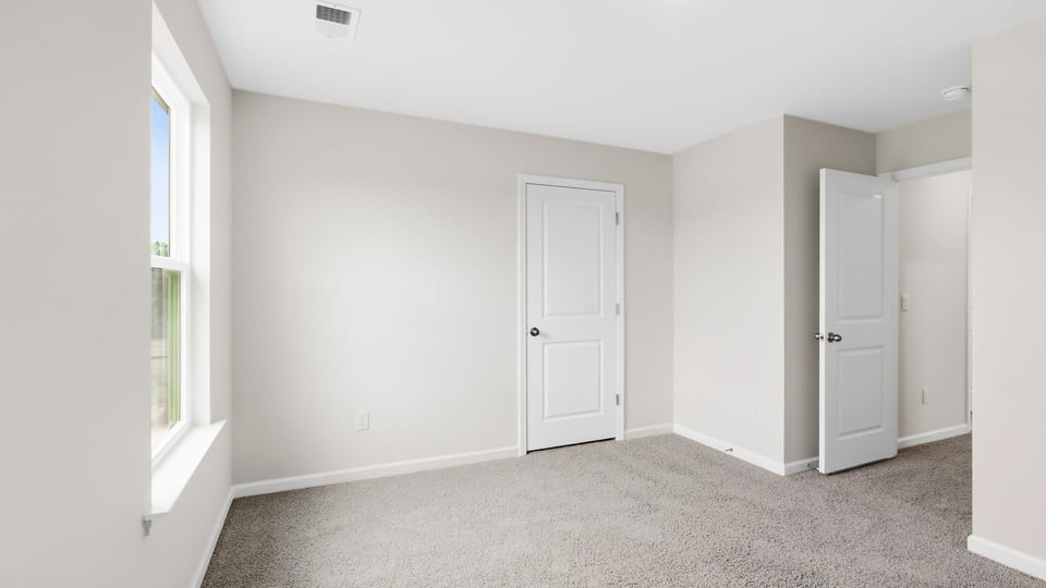 Bedroom with carpet and window.