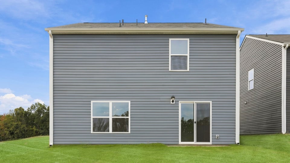 Back exterior of home with large backyard.