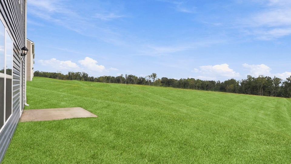 Back exterior of home with large backyard.