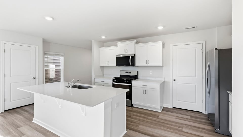 Kitchen and island with quartz countertops.