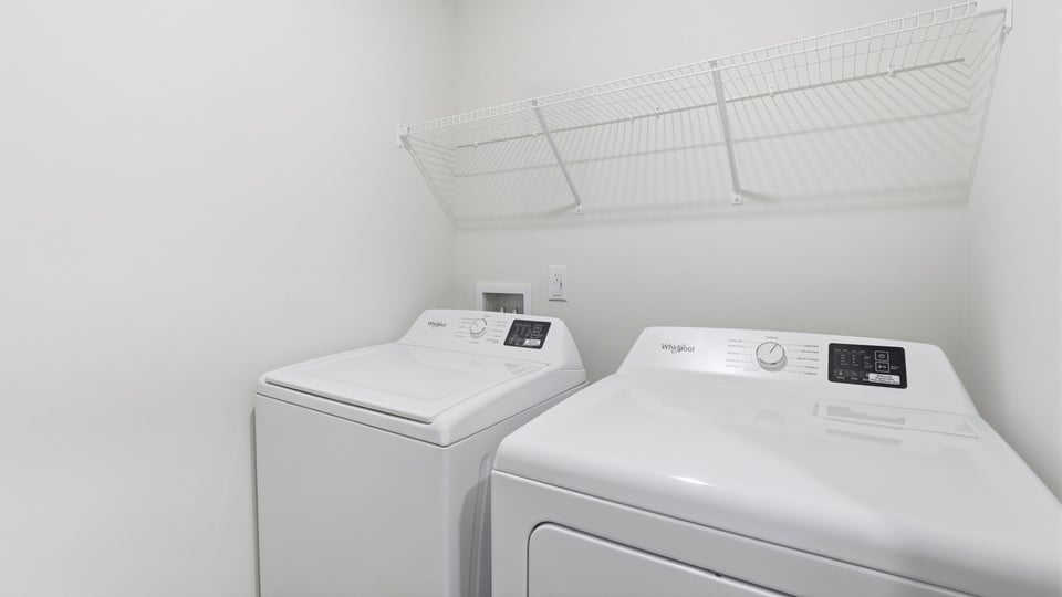 Laundry room with hanging storage racks.