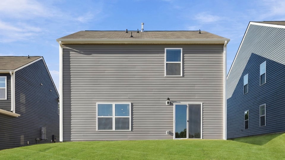 Back exterior of home with large backyard.