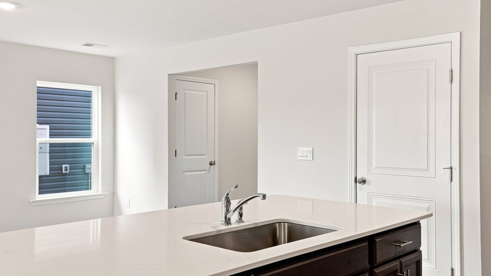 Kitchen and island with quartz countertops.