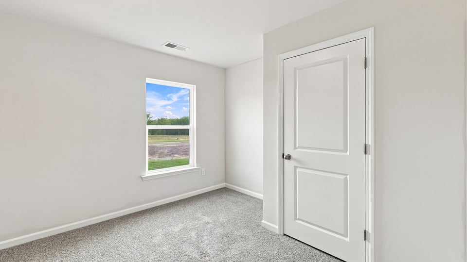 Bedroom with carpet and window.