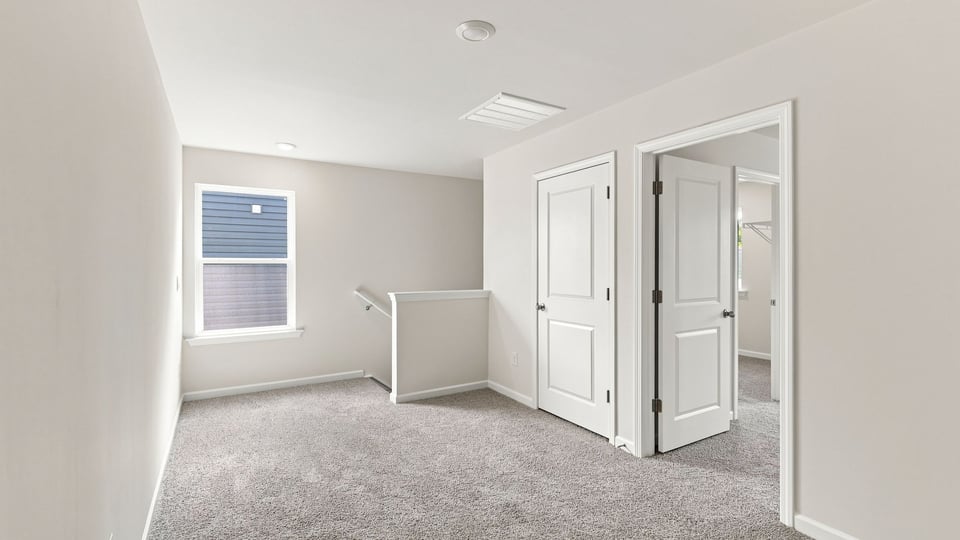 Loft area with carpet and windows.