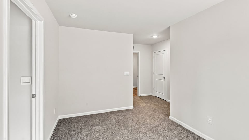 Loft area with carpet and windows.