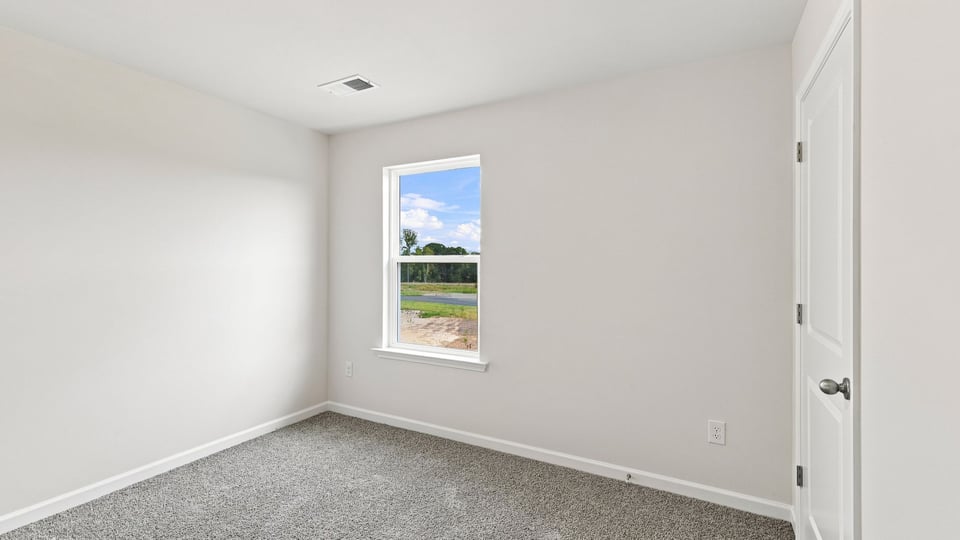 Bedroom with carpet and window.