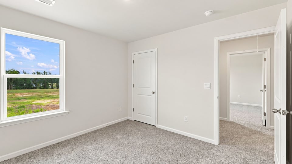 Bedroom with carpet and window.