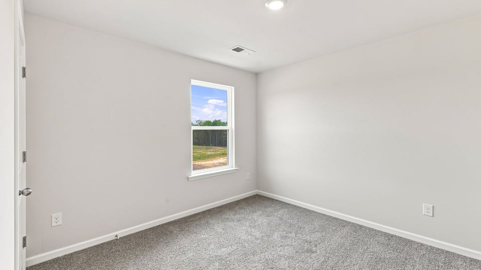 Bedroom with carpet and window.