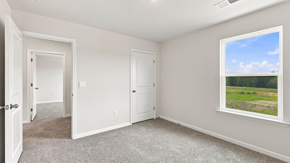 Bedroom with carpet and window.