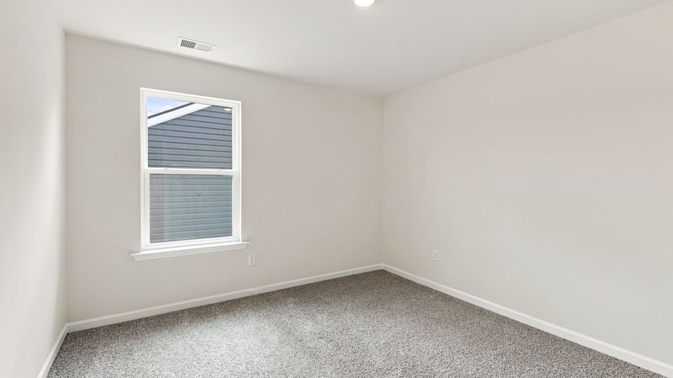 Bedroom with carpet and window.