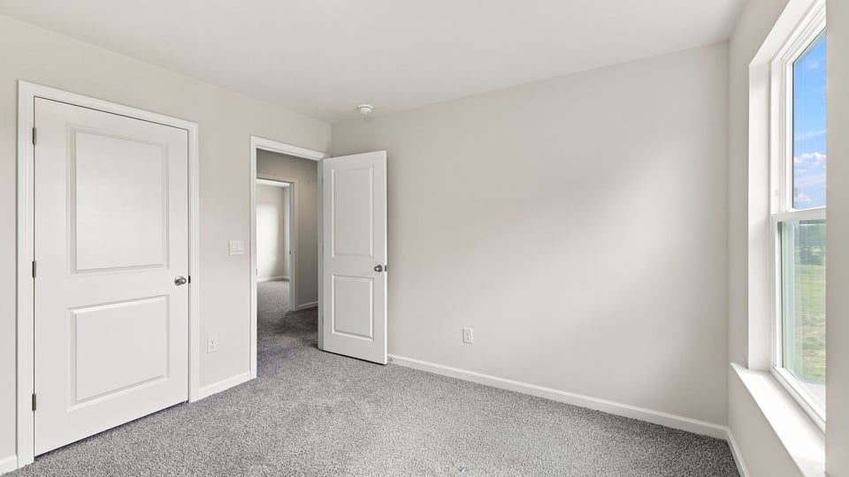 Bedroom with carpet and window.