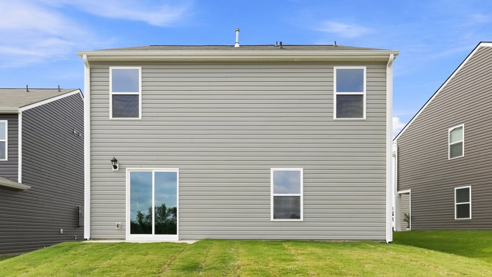 Back exterior of home with large backyard.