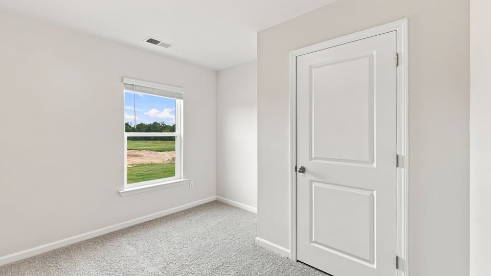 Bedroom with carpet and window.