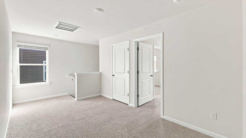 Loft area with carpet and window.