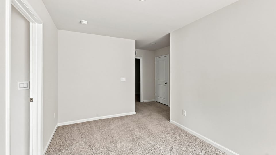 Loft area with carpet and window.