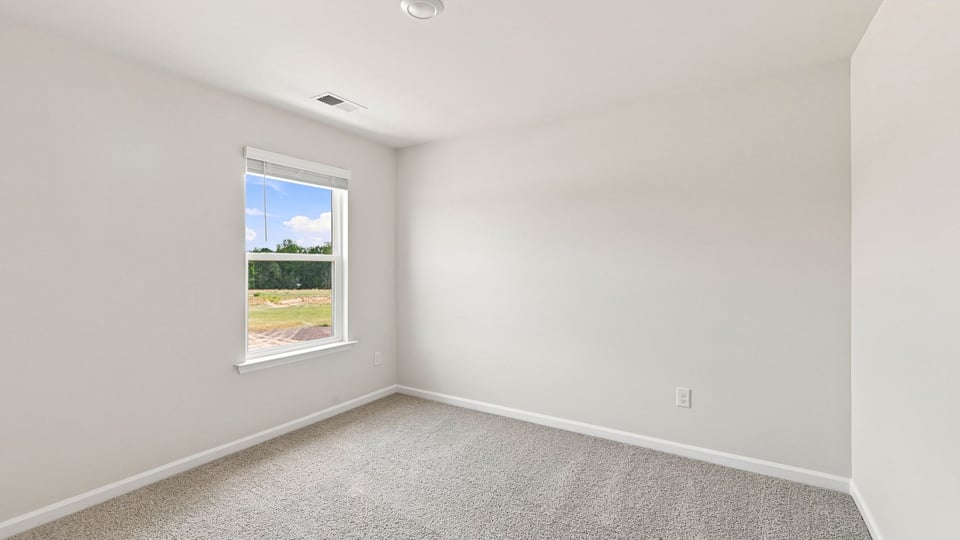 Bedroom with carpet and window.